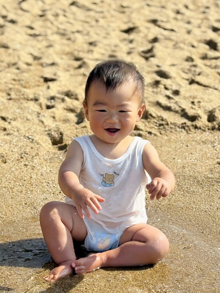 お座りで水遊びする赤ちゃん