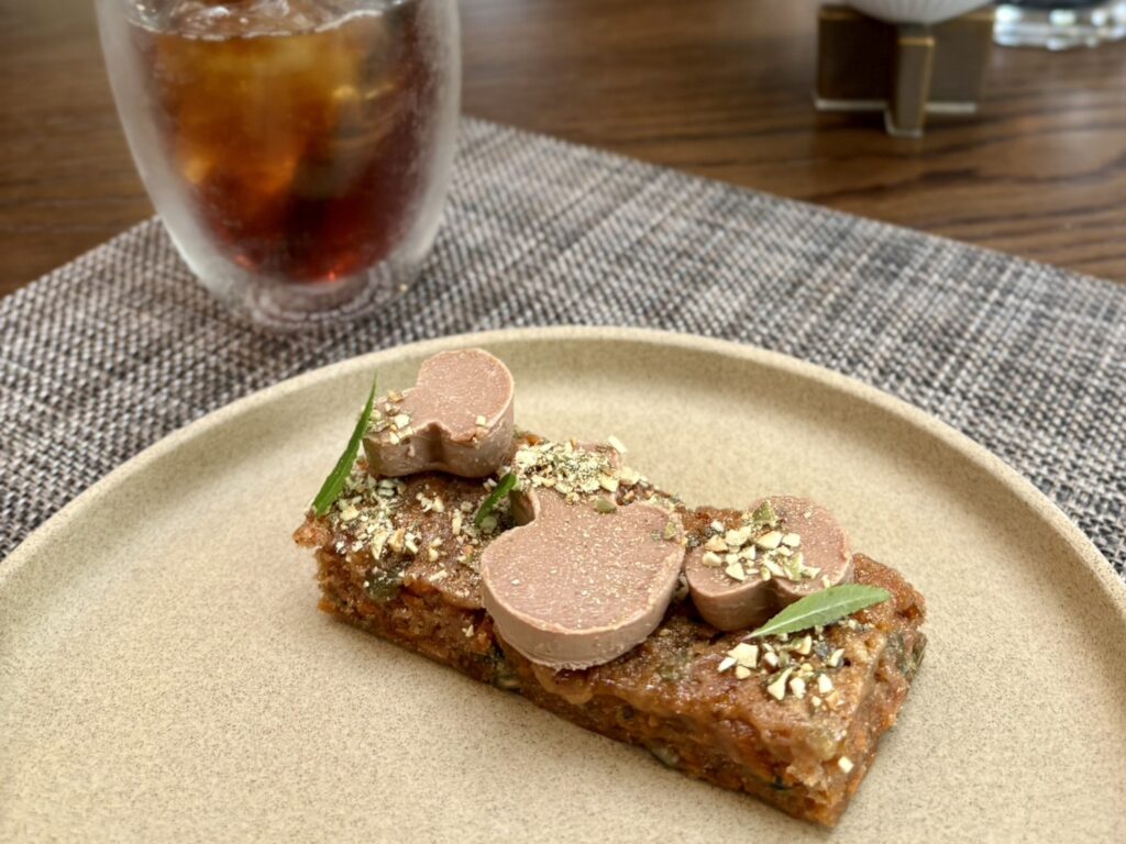 きのこの形のチョコが乗ったキャロットケーキ、秋の庭園を眺めながら楽しむスイーツ
