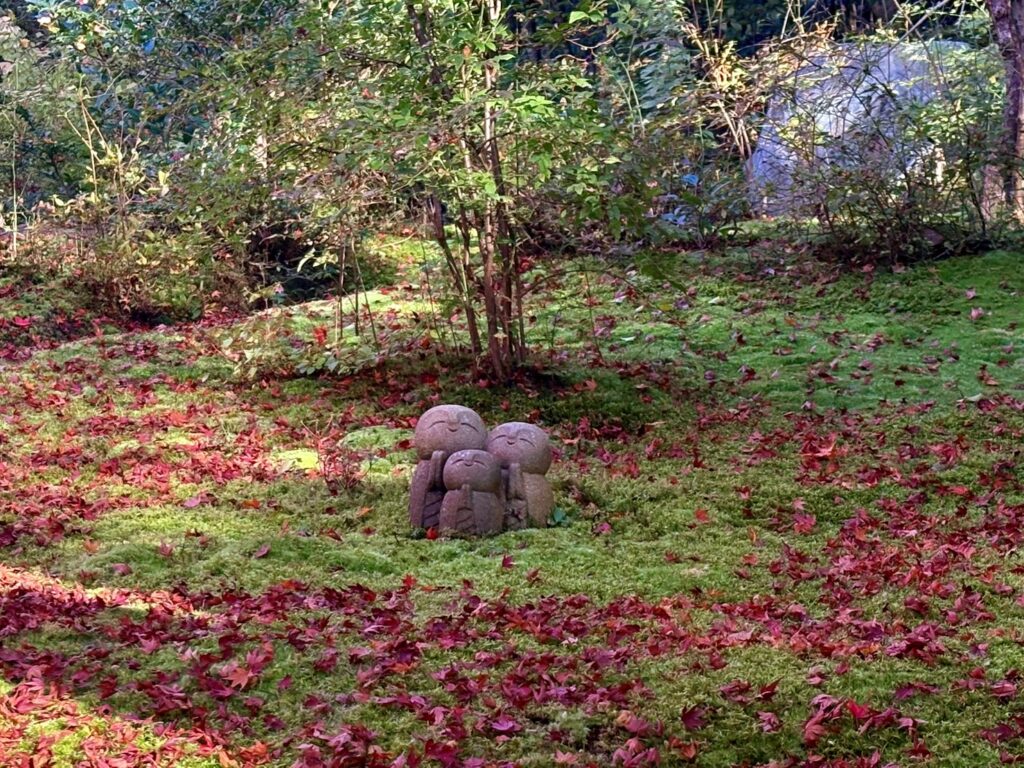 苔の上に落ちた紅葉に佇むちいさなお地蔵さん。