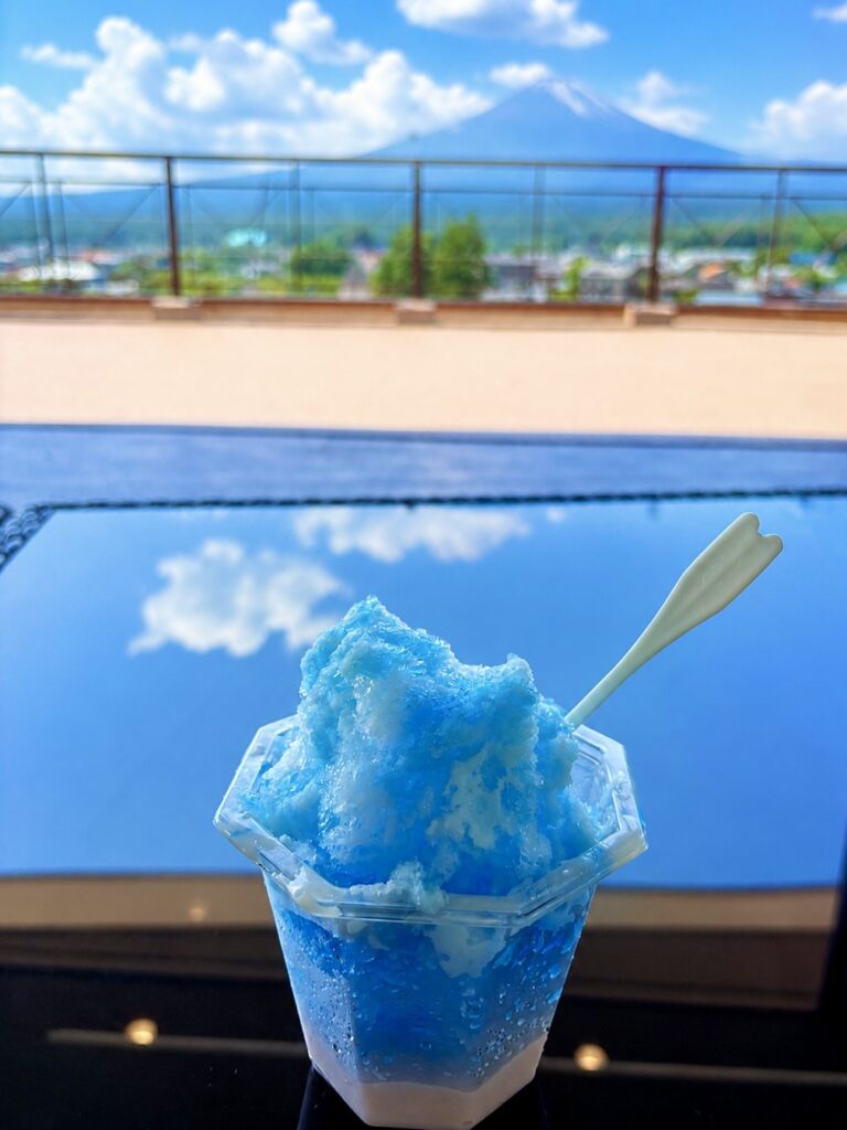 白桃ムースプリンが入った富士山ぷるんかき氷と、雲の切れ間からほんのひととき姿を見せた富士山。