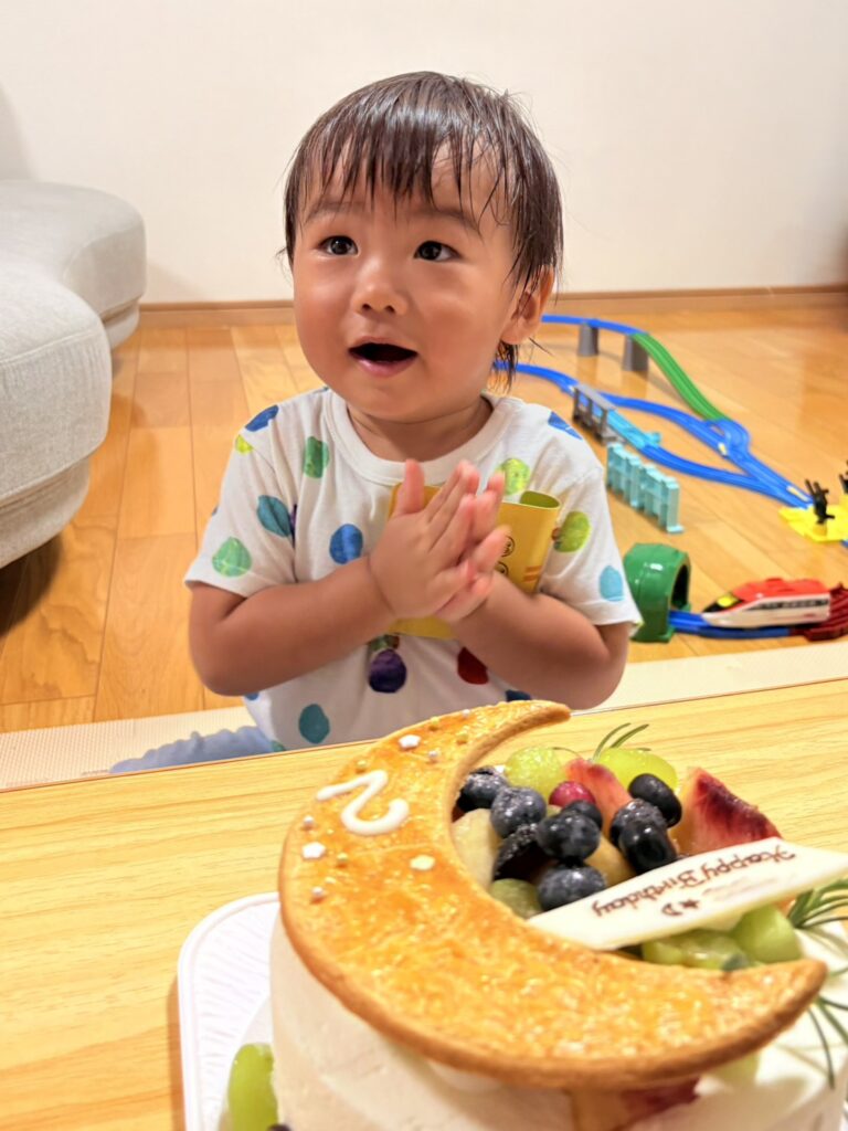 2歳の誕生日ケーキを前にした笑顔。みんなでケーキを囲んで、楽しい誕生日になりました。