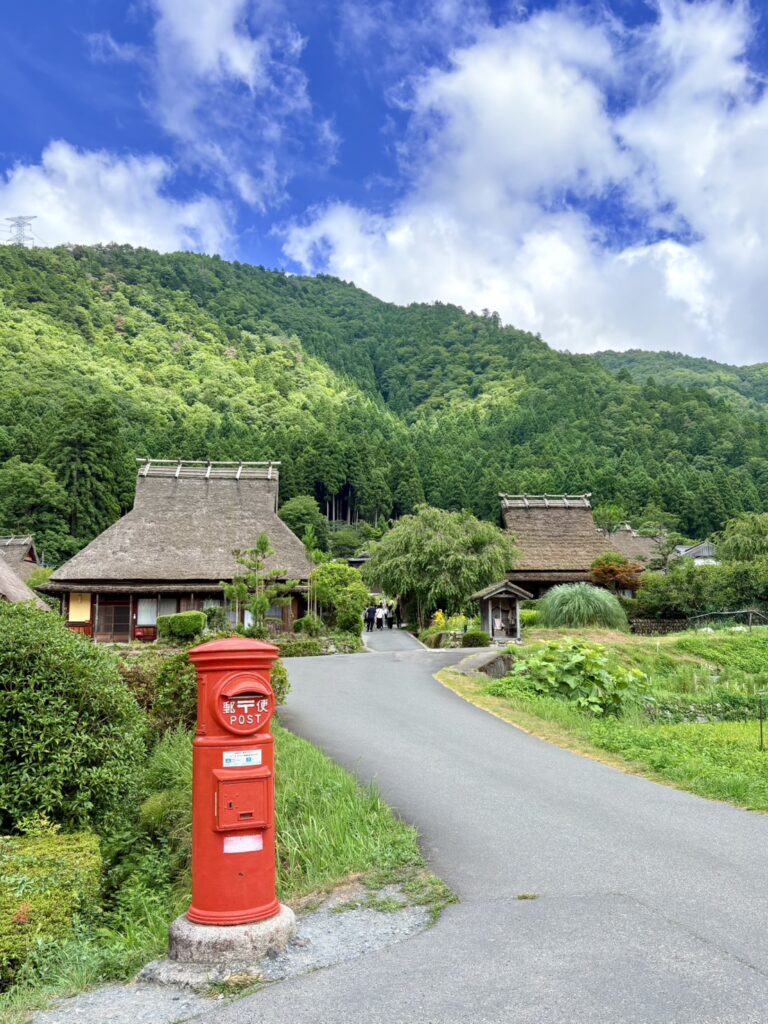 茅葺きの家々に映える赤い郵便ポスト